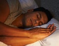 Man, wellness and sleeping in bed at night, health and peace rest on soft pillow on comfortable mattress. Tired person Royalty Free Stock Photo