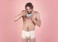 Man with wet hair eat breakfast on pink background. Sexy man with muscular body eating cereal, healthcare. Dieting and