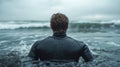 Man in Wetsuit Facing Ocean Waves Royalty Free Stock Photo