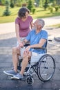 A man in a wheel chair and his wife on a walk in the park Royalty Free Stock Photo