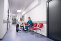 Man in wheelchair communicates with female doctor in corridor outpatient clinic Royalty Free Stock Photo