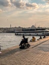 Man on wheelchair fishing by the Bosphorus shore in Karakoy, Istanbul