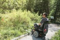 Man on a wheelchair in a forest.