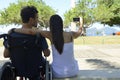 Man in wheelchair and girlfriend taking selfie