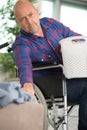 man in wheelchair holding cloth basket Royalty Free Stock Photo