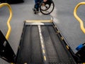 A man in a wheelchair moves to the lift of a specialized vehicle