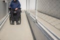 Man in a wheelchair moving along an accessibility pathway Royalty Free Stock Photo