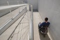 Man on wheelchair moving along an accessible ramp Royalty Free Stock Photo