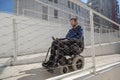 Man on wheelchair moving along an accessible ramp Royalty Free Stock Photo