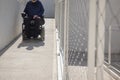 Man on wheelchair moving along an accessible ramp Royalty Free Stock Photo