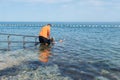 Man on wheelchair on ramp to sea Royalty Free Stock Photo