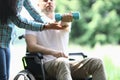 Man in wheelchair sits and holds dumbbell in his hand. Royalty Free Stock Photo