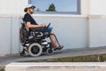 Man in a wheelchair using a building access ramp on a summer vacation Royalty Free Stock Photo