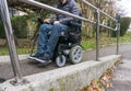 Man in a wheelchair using a ramp next to stairs Royalty Free Stock Photo