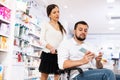 Man in wheelchair and woman in drugstore