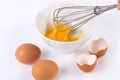 Man Whisking eggs. Whipped eggs in white bowl with two and broken empty egg shell on white background Royalty Free Stock Photo