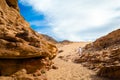 Man in white arab clothing walks in a colored canyon in Egypt Dahab South Sinai