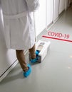 Doctor putting protective shoes on in hospitaly