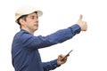 A man in a white construction helmet on a white isolated background looks into the phone and shows his thumb. Brigadier. Builder. Royalty Free Stock Photo