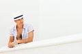 Man in a white hat next to the white wall
