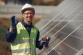 Man in a white helmet near a solar panel Royalty Free Stock Photo