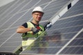 Man in a white helmet near a solar panel Royalty Free Stock Photo