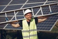 Man in a white helmet near a solar panel Royalty Free Stock Photo