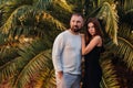 A man in a white jacket and a young girl in a black dress are standing near green bushes.A man and a girl in Italy Royalty Free Stock Photo