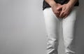 The man in white jeans folded his hands at the level of his genitals. Disease for men. The concept of protection against sexually Royalty Free Stock Photo