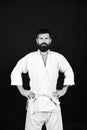 Man in white kimono on black background. Karate man with strict face in uniform. Jiu Jitsu master