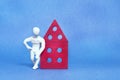 A man in white plasticine is standing leaning on a toy house. Royalty Free Stock Photo
