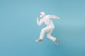 Man in white protective suit respirator mask run jump isolated on blue background studio. Epidemic pandemic new rapidly Royalty Free Stock Photo