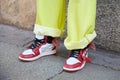 Man with white and red Nike Air Jordan sneakers and yellow jeans before MSGM fashion show, Milan Fashion Week