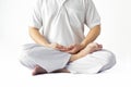 A man in a white robe meditating against a white backdrop with a clipping path