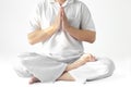 A man in a white robe meditating against a white backdrop with a clipping path