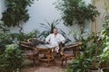 Man in a white robe is resting in a spa center surrounded by green plants Royalty Free Stock Photo