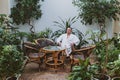 Man in a white robe is resting in a spa center surrounded by plants Royalty Free Stock Photo