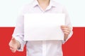 Man with a white sheet of paper in his hands, for your text, mockup. Against the background of the flag of Poland. Unknown person. Royalty Free Stock Photo