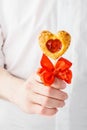 Man in a white shirt giving a heart shaped pie pops on a stick.