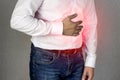 A man in a white shirt holds on to the abdomen, abdominal pain, heartburn, close-up