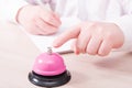 A man in a white shirt presses a finger on a pink service bell and signs a contract Royalty Free Stock Photo