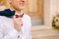 A man in a white shirt and with red bow tie holds a jacket thrown over his shoulder Royalty Free Stock Photo