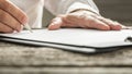 Man in white shirt signing business document