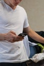 Man in white shirt using phone beside laundry pile Royalty Free Stock Photo