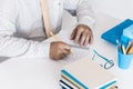 Man in white shirt and yellow tie making notes on modern stylish work place with office supplies, glasses, notebooks and books, Royalty Free Stock Photo