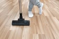 A man in white socks has cleaned the house and is standing with a vacuum cleaner on a clean floor Royalty Free Stock Photo