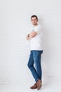 Man in white T-shirt and blue jeans on a white background