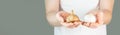 A man in a white t-shirt on a green background holds garlic and black garlic bulbs in his hands. fermented garlic in man`s hands. Royalty Free Stock Photo