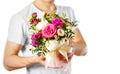 Man in white t shirt holding in hand rich gift bouquet. Composition of flowers in a pink hatbox. Tied with wide white ribbon and Royalty Free Stock Photo