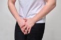 A man in a white T-shirt suffers groin pain. The problem with urology